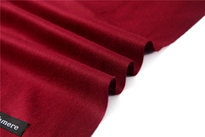 Detail of burgundy cashmere scarf featuring premium twill weave fabric and soft texture