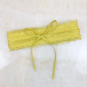 Detailansicht des gelben Spitzen-Taillengürtels mit Blumenmuster und kleiner Schleife