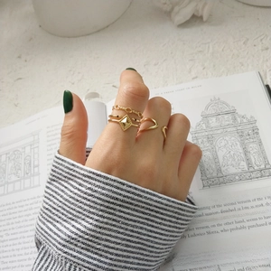 Close-up of three gold-plated 925 silver rings with chain and rhombus patterns