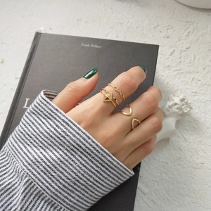 Three-piece set of minimalist gold geometric rings with textured band and rivet details