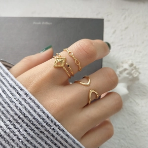 Close-up of assorted gold geometric 925 sterling silver rings worn on model fingers