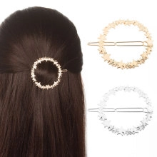 Detail of star-shaped metal hair clips in gold and silver finish on model and white backdrop