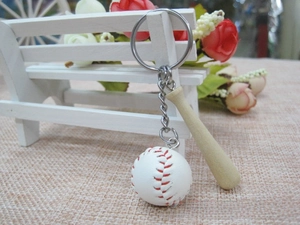 Macro view of mini baseball bat and leather ball keychain on a decorative white bench