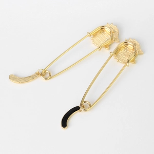 Detail of cute gold cat brooches with hanging tail charms and black enamel finish