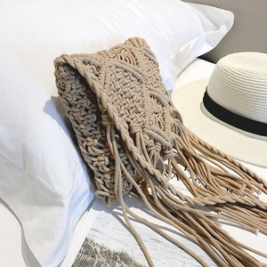 Détail du sac à bandoulière en corde de coton beige avec motifs en losange et longues franges