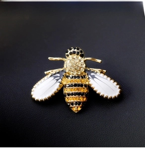 Macro shot of bee brooch featuring gold plating, enamel wings and sparkling rhinestones