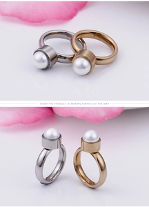 Détail de la bague en acier inoxydable poli avec une grande perle d'imitation blanche