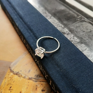 Macro view of S925 sterling silver ring with large square-cut zircon on blue book spine
