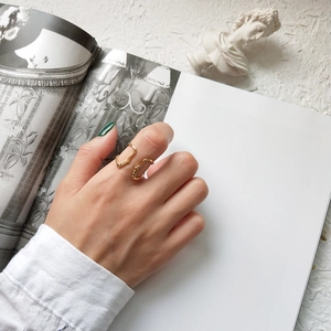 Artistic gold face silhouette open ring worn on hand with classical background elements