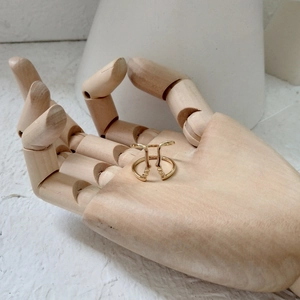 Artistic gold double face profile ring displayed on a wooden mannequin hand model