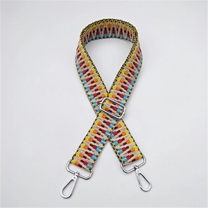Detail of adjustable woven bag strap with colorful ethnic pattern and metal hooks