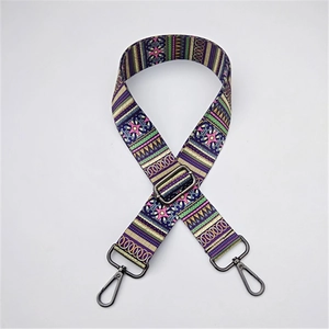 Detail of woven ethnic bag strap with colorful geometric patterns and black metal hooks