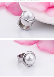 Detail of wide stainless steel ring with a large semi-round white pearl focal point