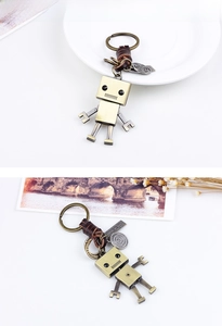 Vue macro du porte-clés robot vintage en bronze avec cuir et détails mécaniques
