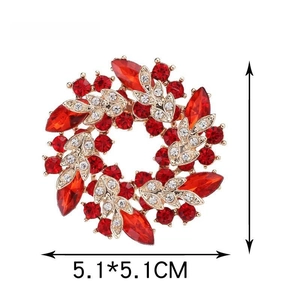 Detailed view of red crystal wreath brooch with dimensions of 5.1x5.1cm in gold setting