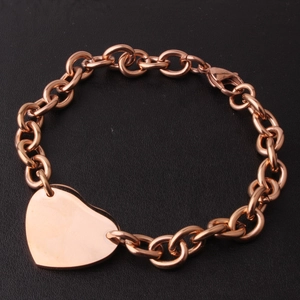 Rose gold stainless steel link chain bracelet featuring a polished heart pendant on black background