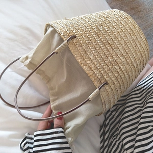 Detail of handmade straw bucket bag with linen drawstring lining for summer vacations
