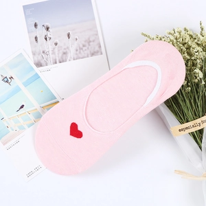 Détail de chaussettes basses roses en coton avec cœur brodé rouge et bordure blanche fine