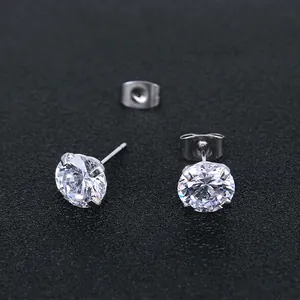 Detailed macro view of silver stainless steel four-prong stud earrings with round zircons