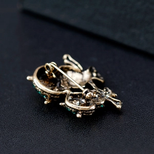 Vintage owl brooch in antique bronze with green gemstone inlay, detailed back view of pin