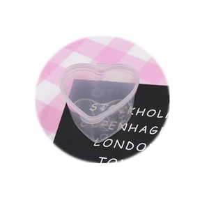 Clear heart-shaped 45ml plastic slime storage box with lid on pink checkered background