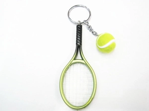 Detailed close-up of a mini green tennis racket and yellow ball keychain charm