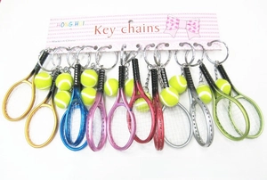 Close-up of colorful mini tennis racket and ball keychains on white background display