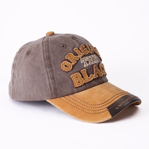 Close-up of vintage grey baseball cap with ginger brim and leather stitched details