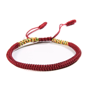 Detail of red handmade braided knot bracelet with adjustable drawstring closure
