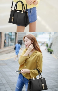 Close-up of black crossbody bag with gold metal hardware and textured leather finish