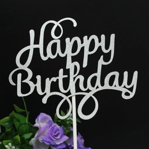 Macro shot of silver glitter Happy Birthday cake topper with sparkling texture
