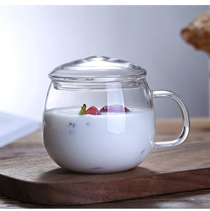Close-up of heat-resistant glass tea cup with lid, yogurt, and strawberries on wood tray