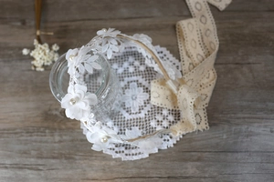 Diadema de encaje con flores blancas, perlas y cintas beige sobre madera rústica