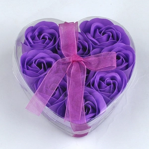 Gift box with 9 purple heart-shaped soap roses and a pink ribbon bow on white background