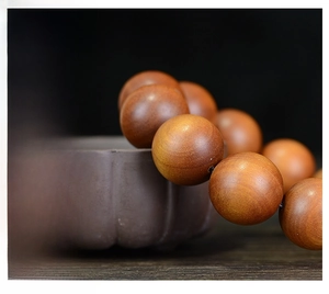 Detail of Indonesian Sandalwood prayer beads draped on a traditional ceramic jar