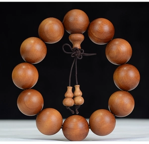 Macro detail of natural brown sandalwood prayer beads with smooth texture and oil finish