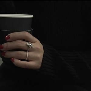 Close-up of vintage 925 sterling silver ring set worn by model against dark aesthetic