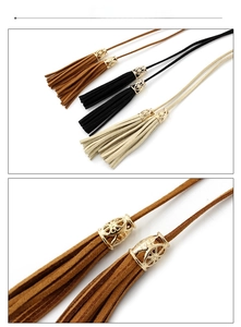 Close-up of bohemian tassel belts featuring hollow gold metal caps and suede fringes