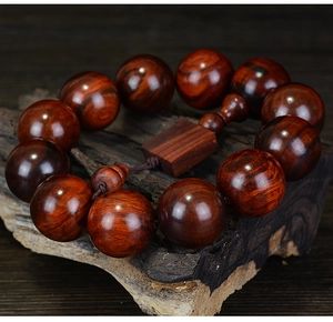 Macro d'un bracelet bouddhiste en bois de rose avec plaque carrée sur socle brun