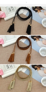 Detail of ethnic tassels waist rope in black, brown, and beige with hollow metal charms