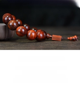 Vue macro des perles de prière en bois de rose poli montrant le grain naturel du bois
