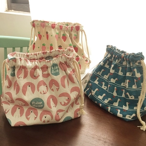 Détails de sacs bento en coton et lin avec trois motifs posés sur une table en bois