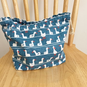 Vue détaillée du sac bento japonais bleu avec motifs de canards et cordon en coton