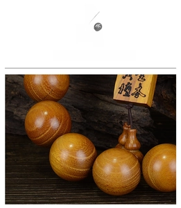 Makroaufnahme von Gold-Sandelholzperlen mit Seidentextur und dekorativem Kürbis