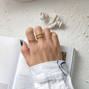 Detailed view of three stackable gold rings featuring Love script and vine leaf textures
