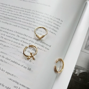 Detailed view of gold plated adjustable rings with zircons on a vintage book page
