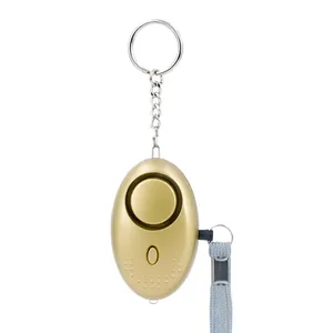 Golden oval personal security alarm with silver keychain and grey braided wrist strap