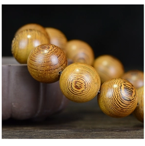 Macro de perles en bois de Wengé montrant le grain naturel et la texture polie