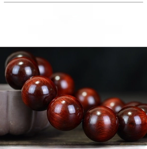 Macro shot of polished dark red sandalwood beads with oily texture and natural grain