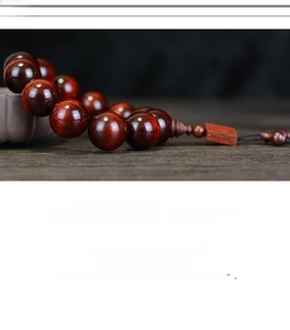 Macro shot of polished red sandalwood beads showcasing authentic fine wood grain texture